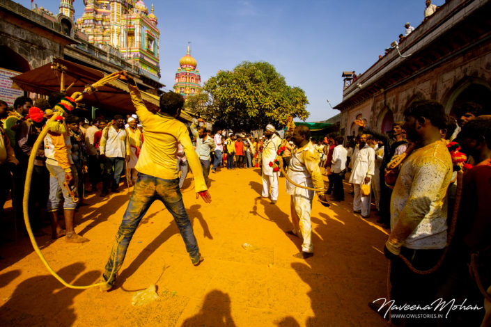 People whipping amidst cheering crowd