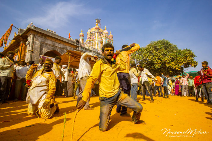 People whipping amidst cheering crowd